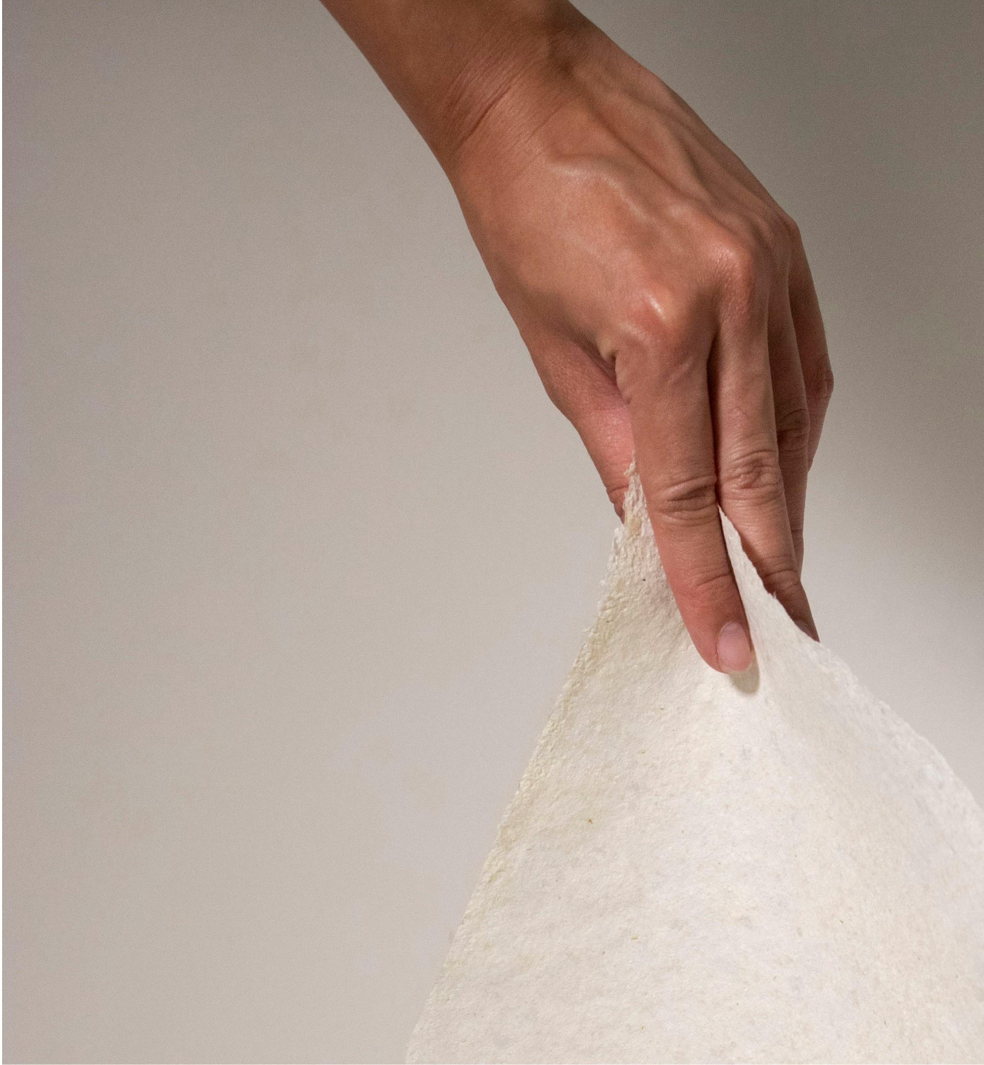 Hand lifting a sheet of fish-scale paper